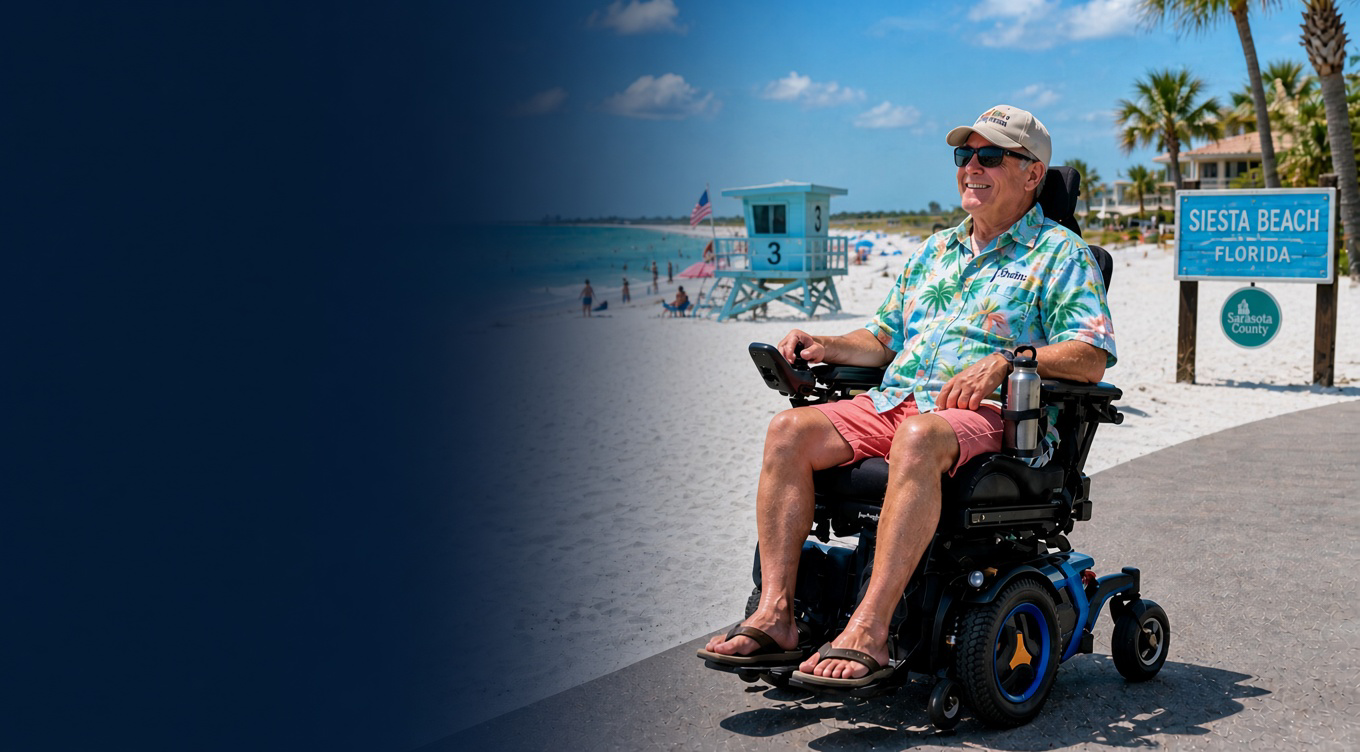 Smiling man in sunglasses and tropical shirt using a motorized wheelchair on a sunny boardwalk at Siesta Beach, Florida, with a lifeguard stand and palm trees in the background.